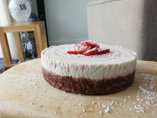 Raw vegan strawberry vanilla cheesecake with a chocolate brownie base